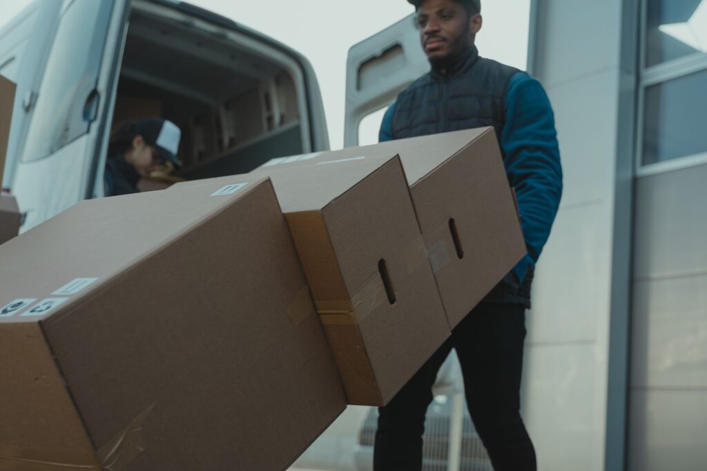 Professional villa movers Abu Dhabi loading large cardboard boxes into the back of a white moving truck during a luxury home relocation.