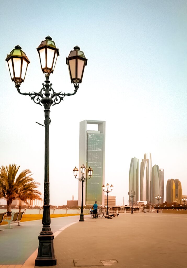 Classic street lamppost along the Abu Dhabi Corniche pathway with the city skyline in the background, representing local coverage for packing and unpacking services Abu Dhabi.