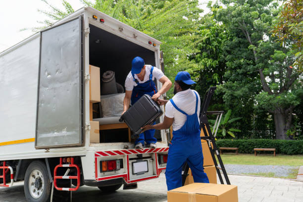 Professional team members loading furniture and suitcases into a large white transit truck, demonstrating reliable services from movers and packers Khalifa City.