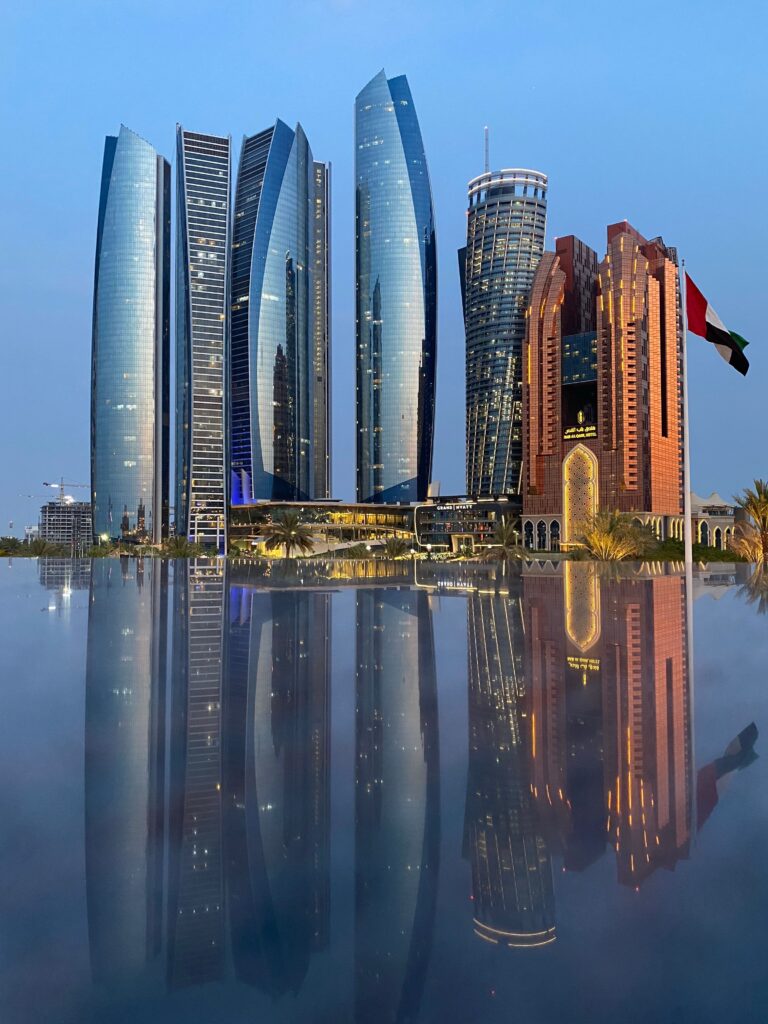 Etihad Towers and Abu Dhabi skyline reflection highlighting the primary service areas for professional villa movers Abu Dhabi.