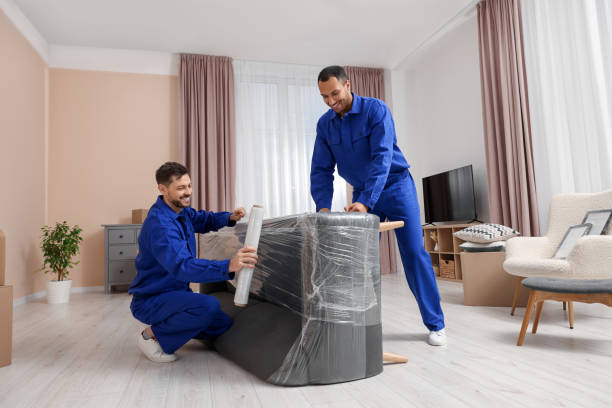 Experienced house movers Abu Dhabi packing and wrapping furniture inside a spacious villa.