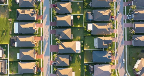Aerial view of residential rooftops and streets in a gated Abu Dhabi neighborhood.