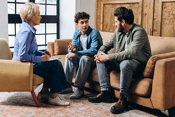 Family having a discussion with a counsellor in a living room about moving with kids in Abu Dhabi.