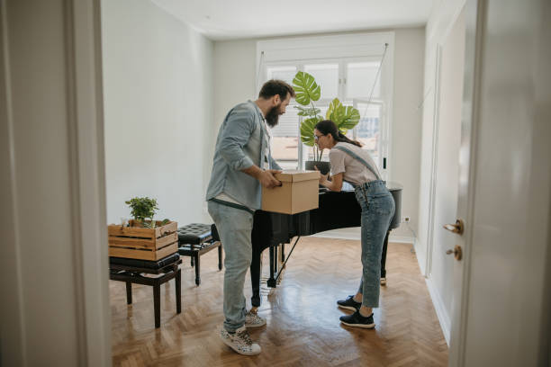 Homeowners packing general furniture items near a grand piano during a residential move in Abu Dhabi.